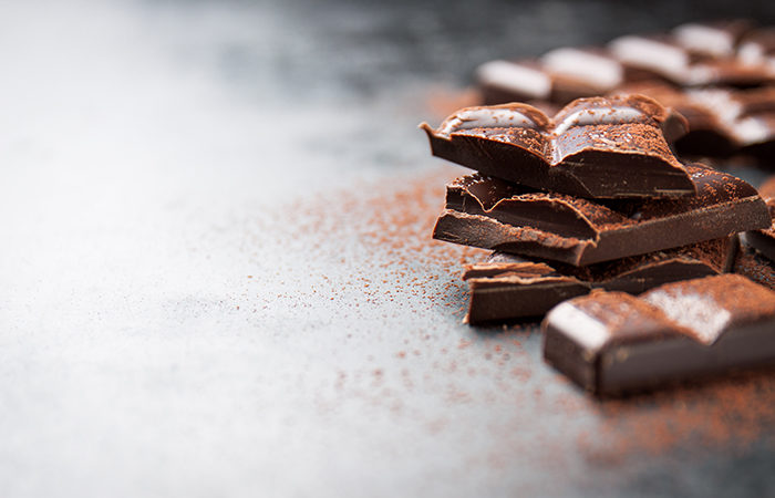 Dark chocolate on a dark background, closeup with place for text, selective focus